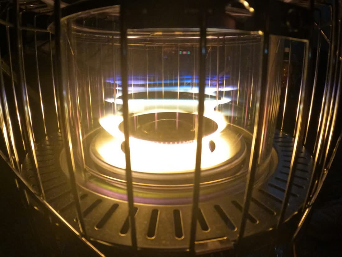 Close-up of a multi-pocket electron beam evaporation source glowing softly.